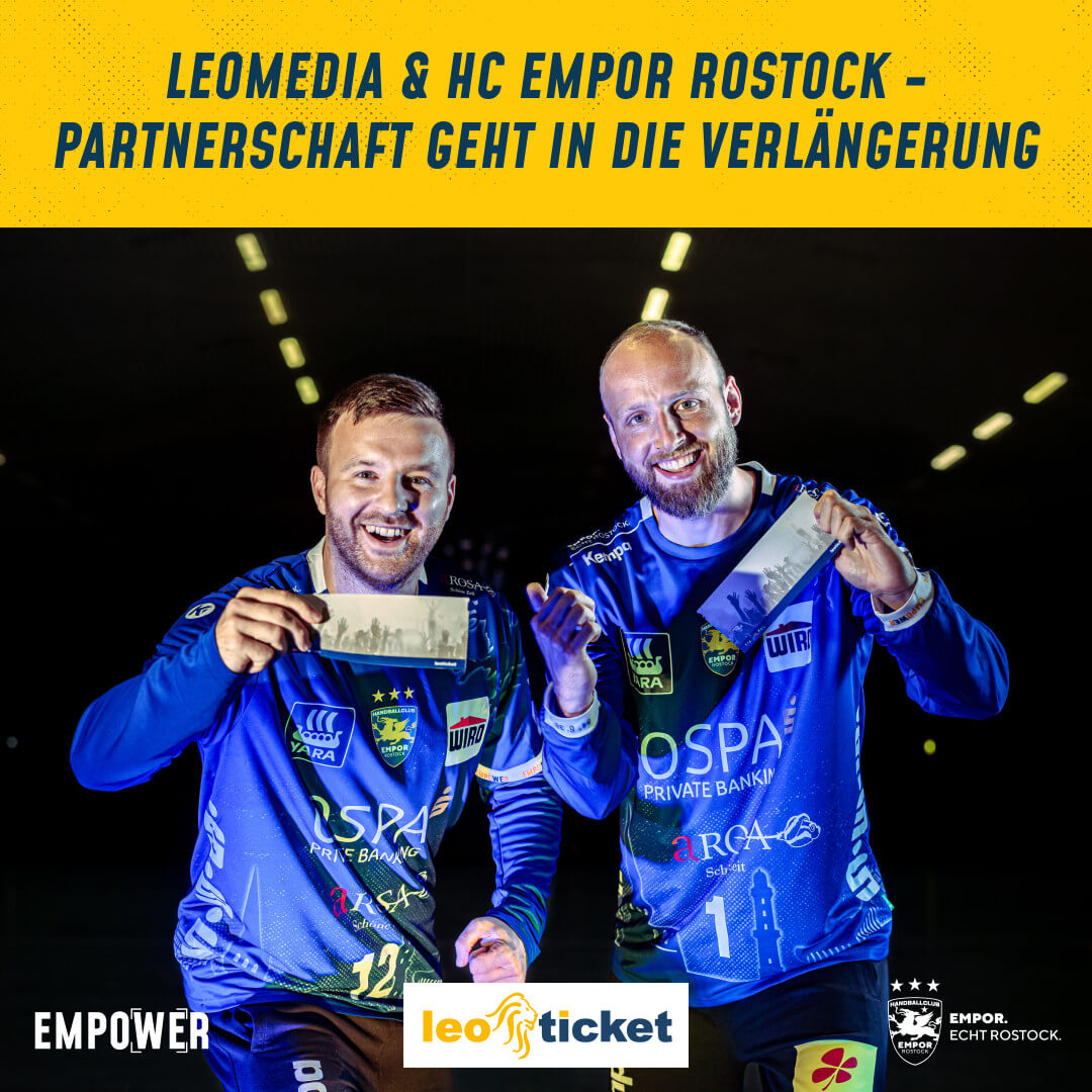 Zwei Handballspieler halten lächelnd Tickets in die Kamera.